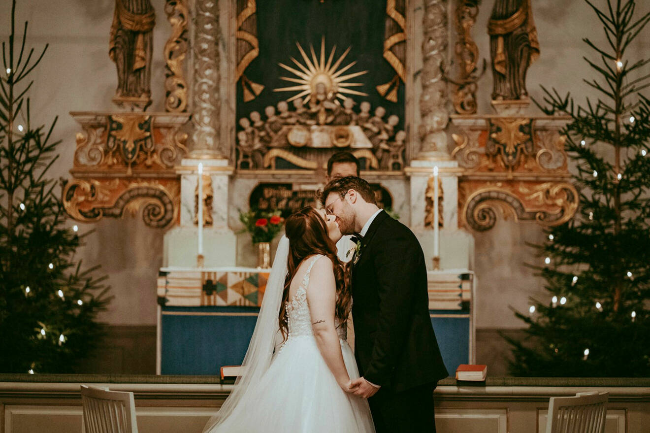 Elin och Albin kysser varandra vid altaret i kyrkan när de gifter sig.