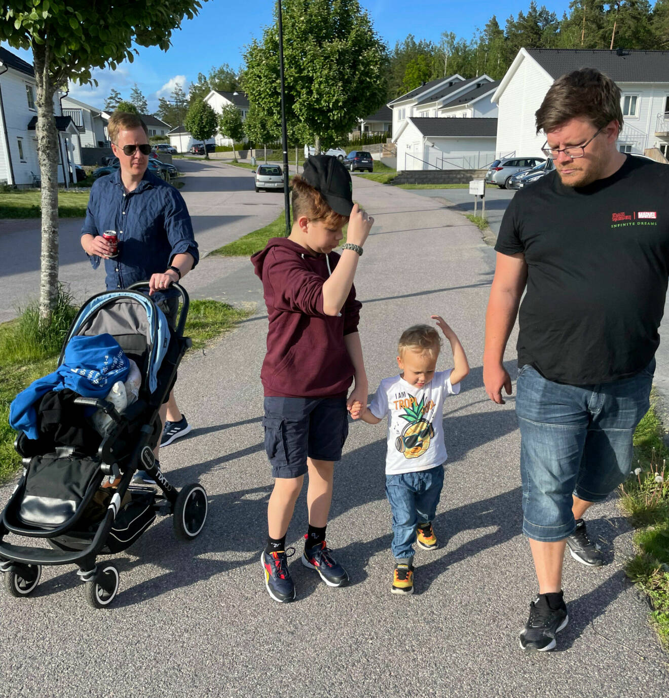 Thomas och Max är ute på promenad med två av barnen. Thomas går med en barnvagn.