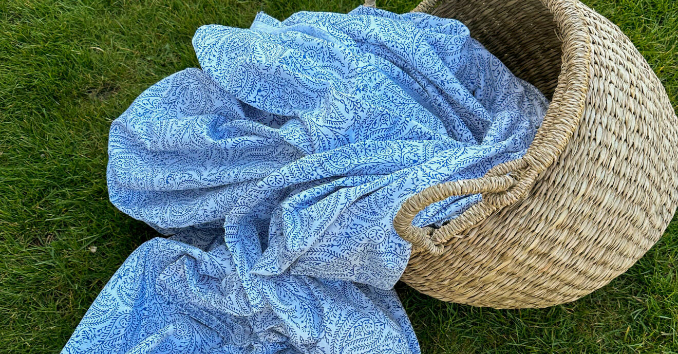 En rottingkorg med tyg i blått och vitt