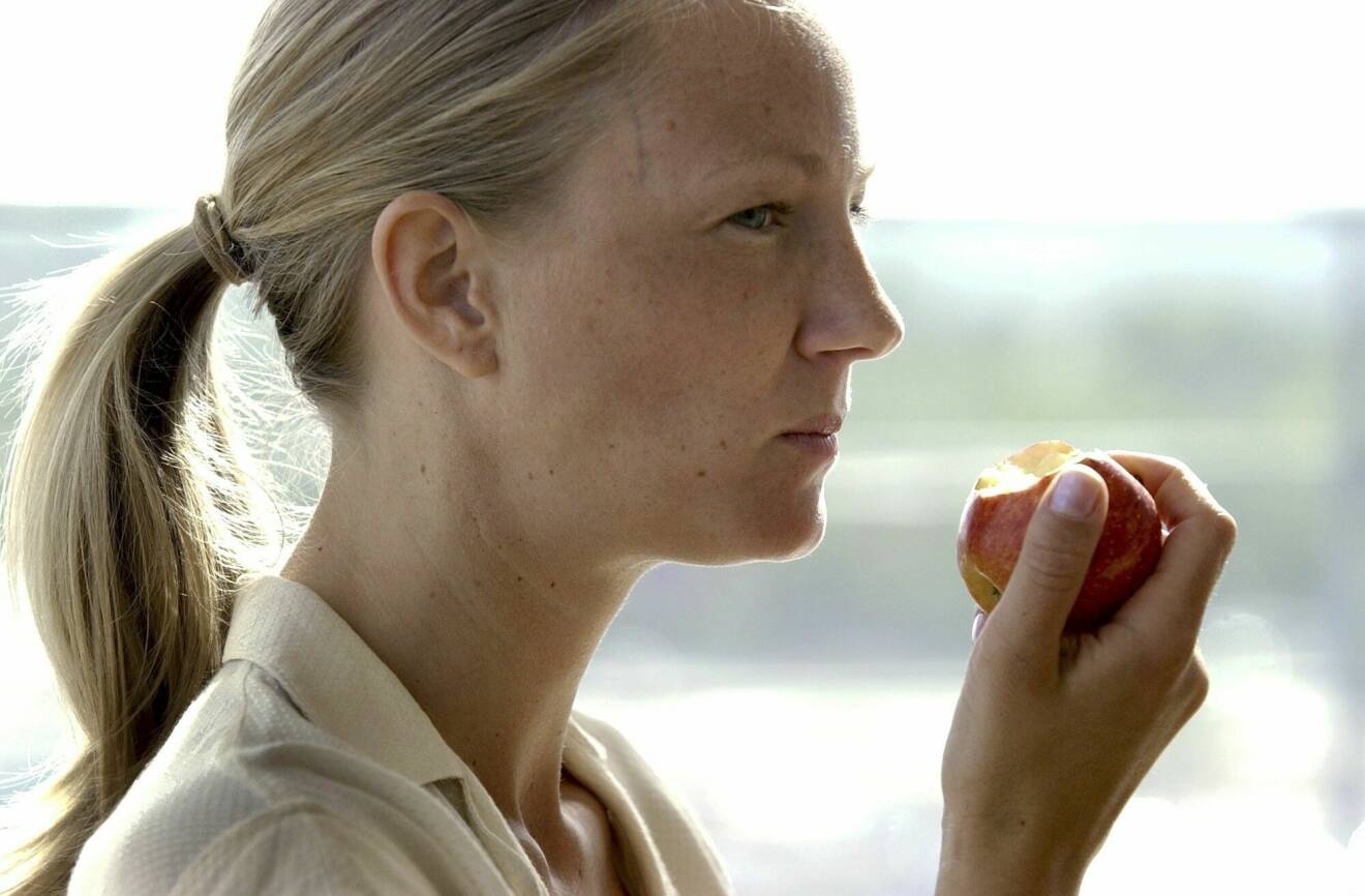 En kvinna som äter ett äpple