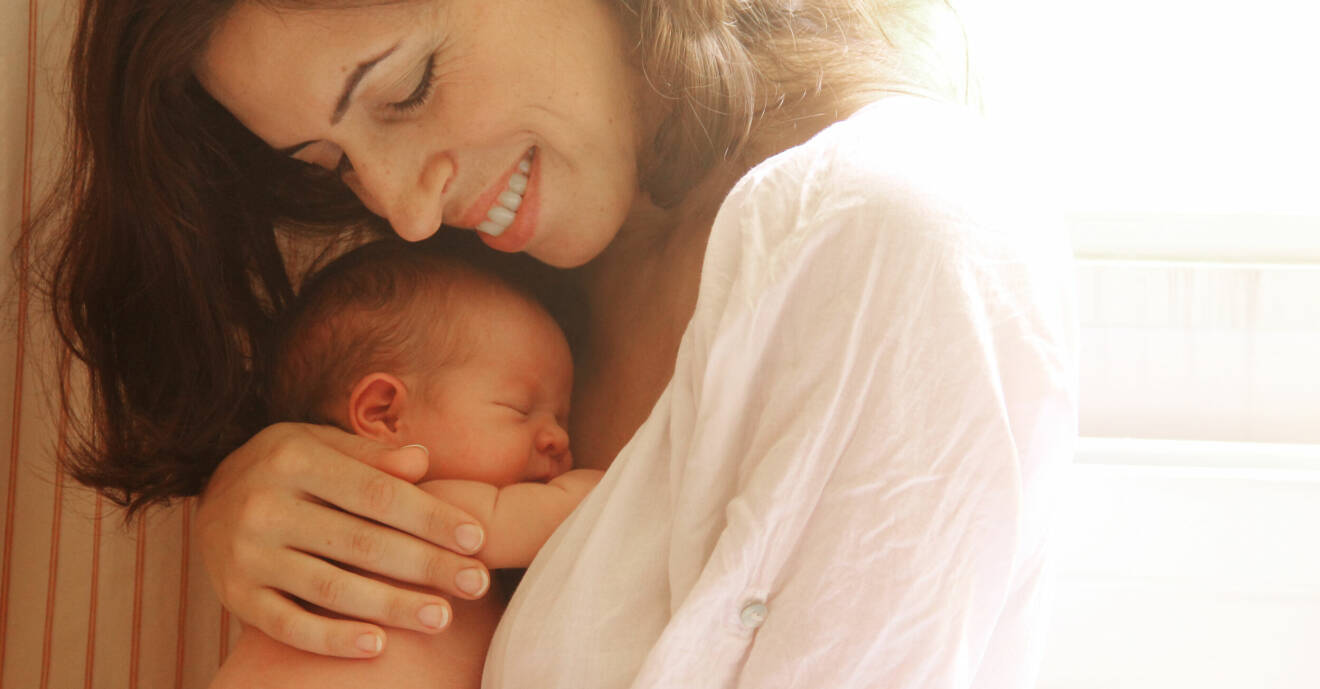 En kvinna som håller i en bebis
