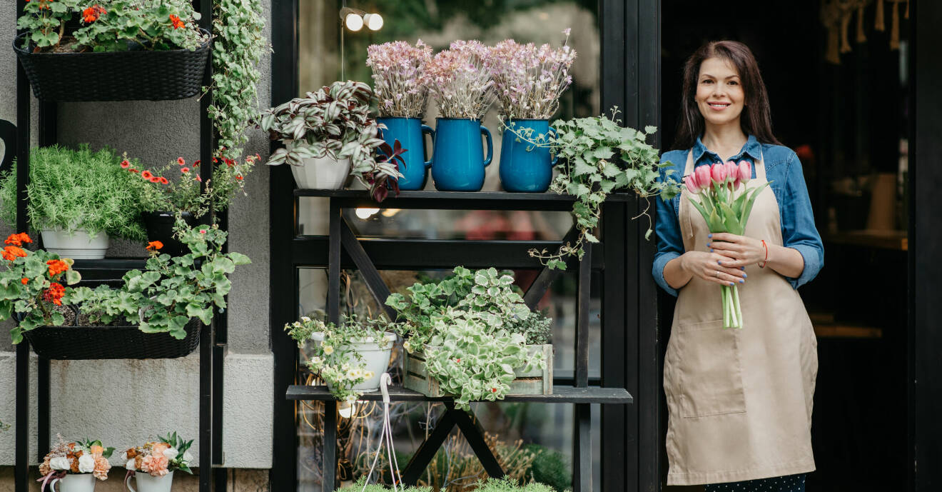 En kvinna som står vid en blomsterbutik