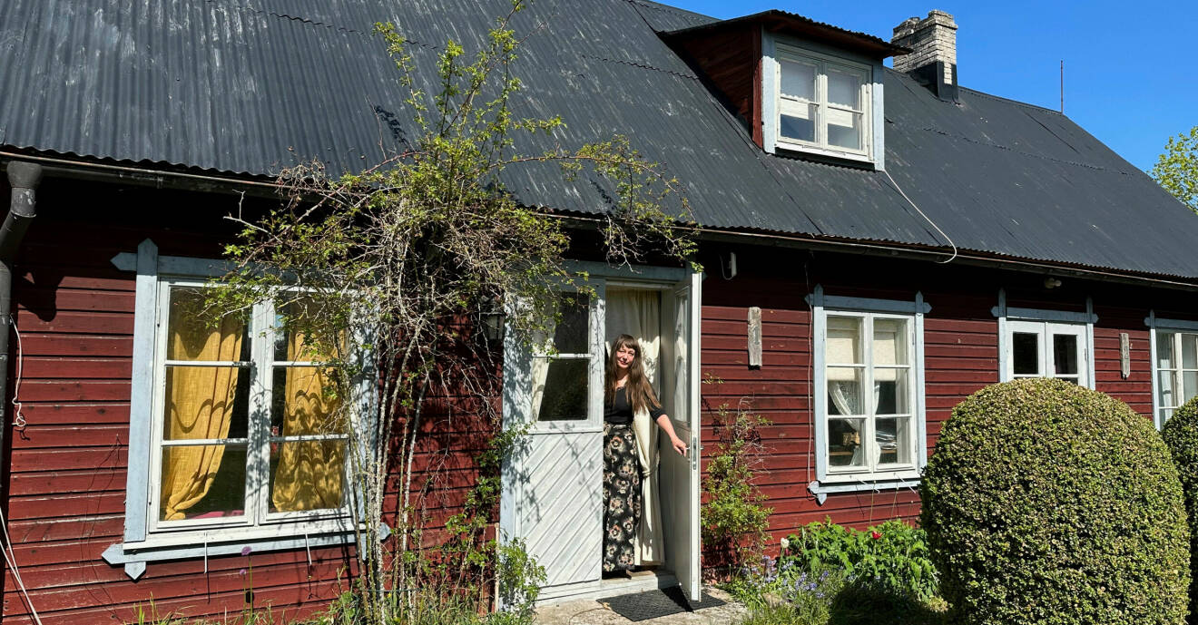 JoAnn står vid sitt röda hus på Gotland