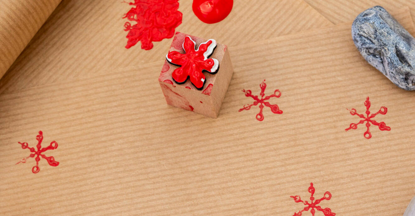 Julstämplar stämplas på ett rött papper