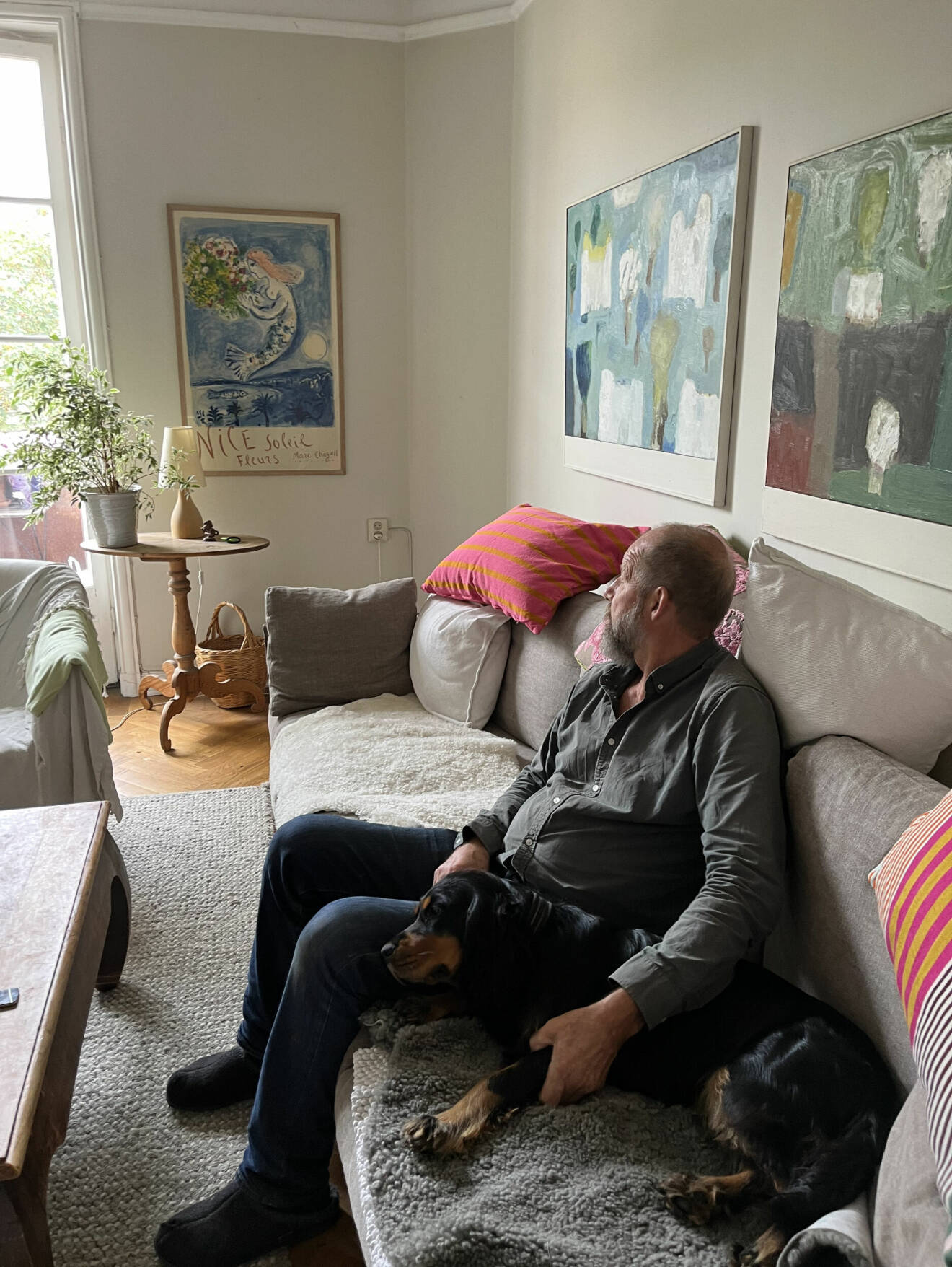 Walter sitter i vardagsrummet med hunden Bella