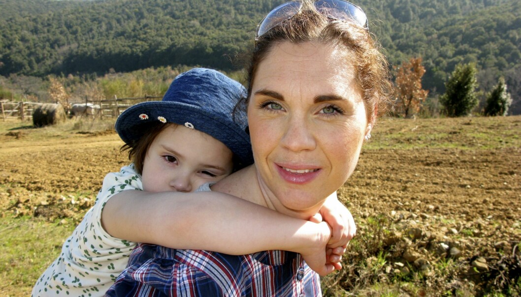Catrin Kylberg med sin cancersjuka dotter Leia på ryggen.
