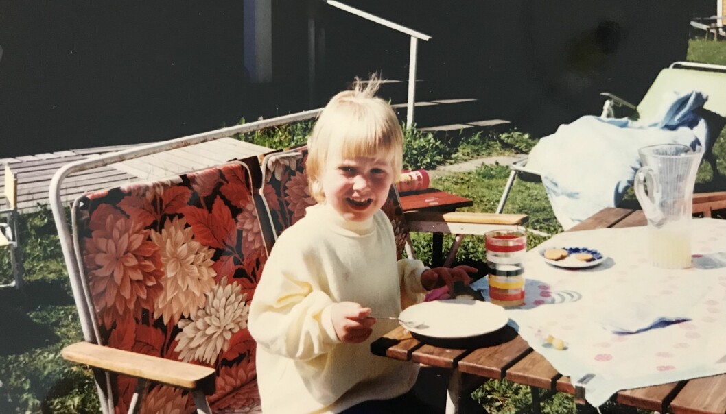 När föräldrarna bråkade och sa att de skulle skilja sig protesterade Åsa och hennes syster högt och vilt. Foto: Privat Lilla Åsa sitter vid ett trädgårdsbord och fikar.