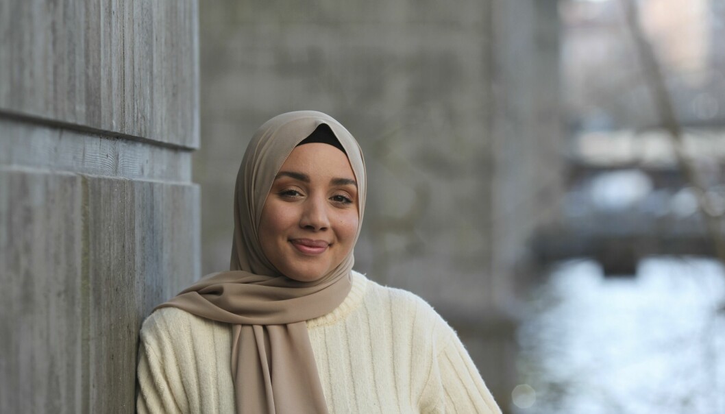 Bakinfluencern Camilla Hamid lutar sig mot en bropelare.