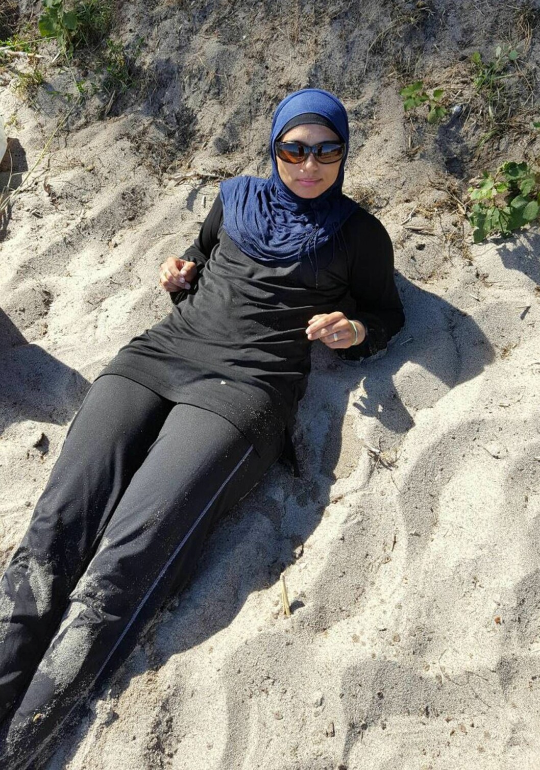 Ibland känner Inaam sig ovälkommen på stranden, för att hon är påklädd. Foto: Privat Inaam Arabi ligger på stranden iklädd burkini