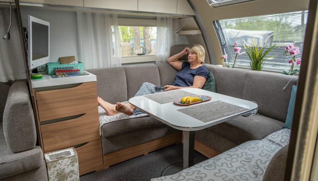 Inger Axelsson ligger i tv-soffan inne i husvagnen.