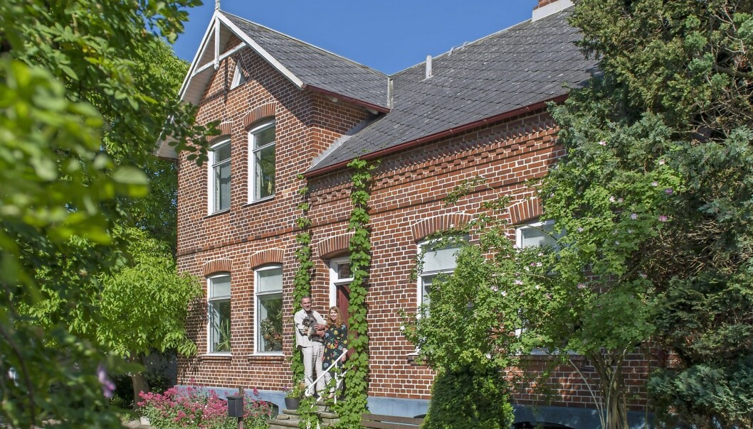 Anna-Karin och Jonas med familjens hund utanför deras sekelskifteshus. Huset som omgärdas av familjen Elfversons vackra självgående trädgård.