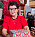 Irene sitter vid köksbordet, i förd en röd topp och sitter med färgglada julklappar framför sig.