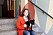 Isabella med sin hundvalp Penny på en yttertrappa med färgglad väggmålning i bakgrunden. 