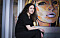 Jasmina sitter på soffkanten i Talitas kontor i Enskede, framför en tavla som föreställer en kvinna.