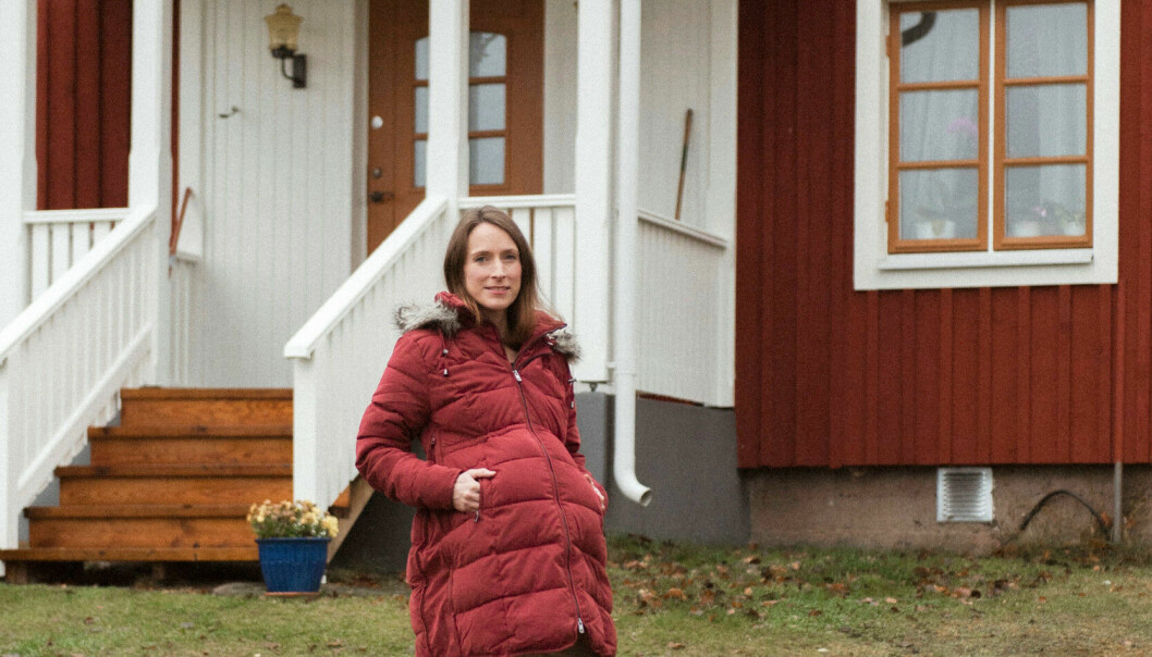 På sjukhuset var Jenni uppkopplad mot en maskin som höll koll på att blodet syresattes. Varje dag kom en barnmorska och kollade hjärtljudet på barnet i magen. Jenni står framför sitt hus, hon har på sig en röd lång dunjacka och hon är gravid.