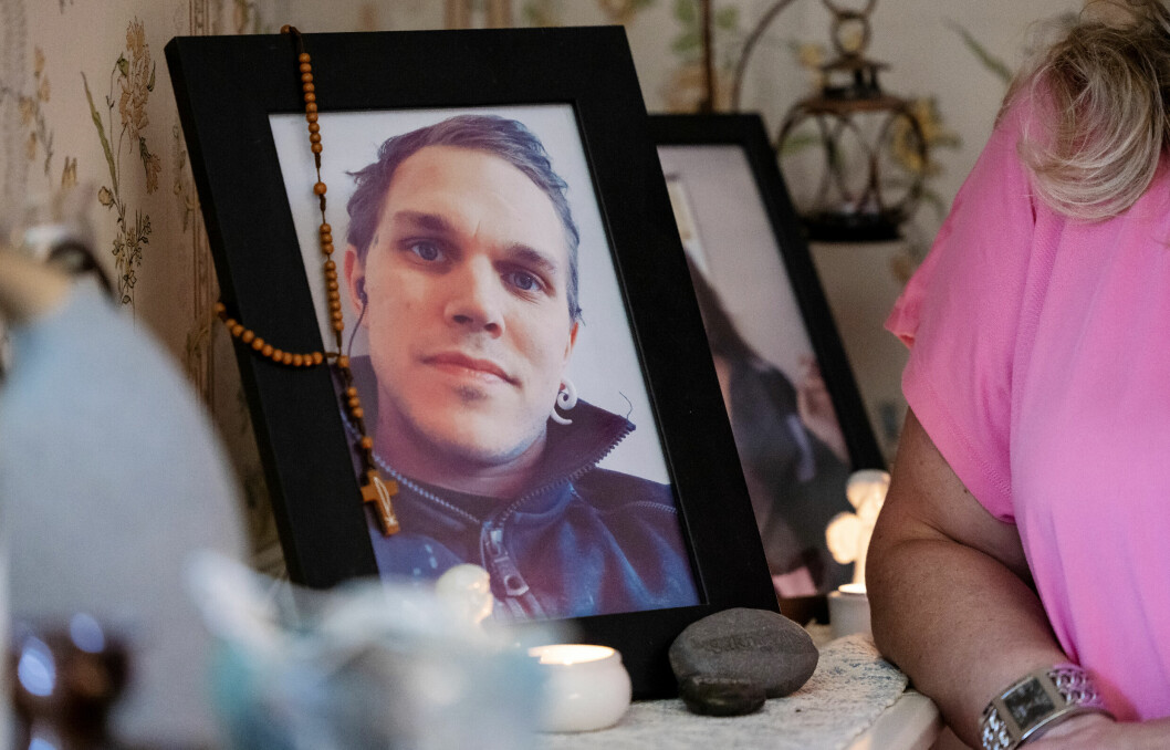 Anette står vid ett fotografi av sin döde son Joakim.