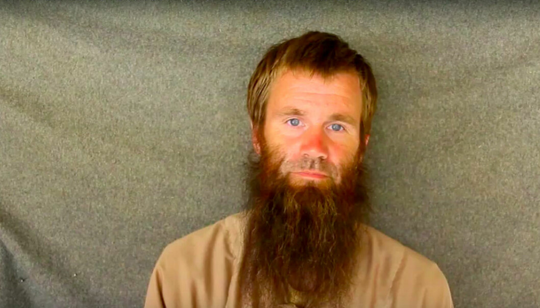 Johan Gustafssonstår mot ett skynke och har långt skägg efter en tids kidnappning i Mali