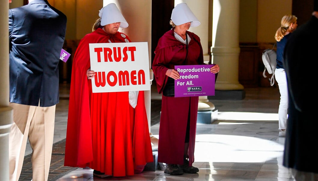 Kvinnor, klädda som karaktärer i handmaid's tale, protesterar mot Alabamas stränga abortlag.
