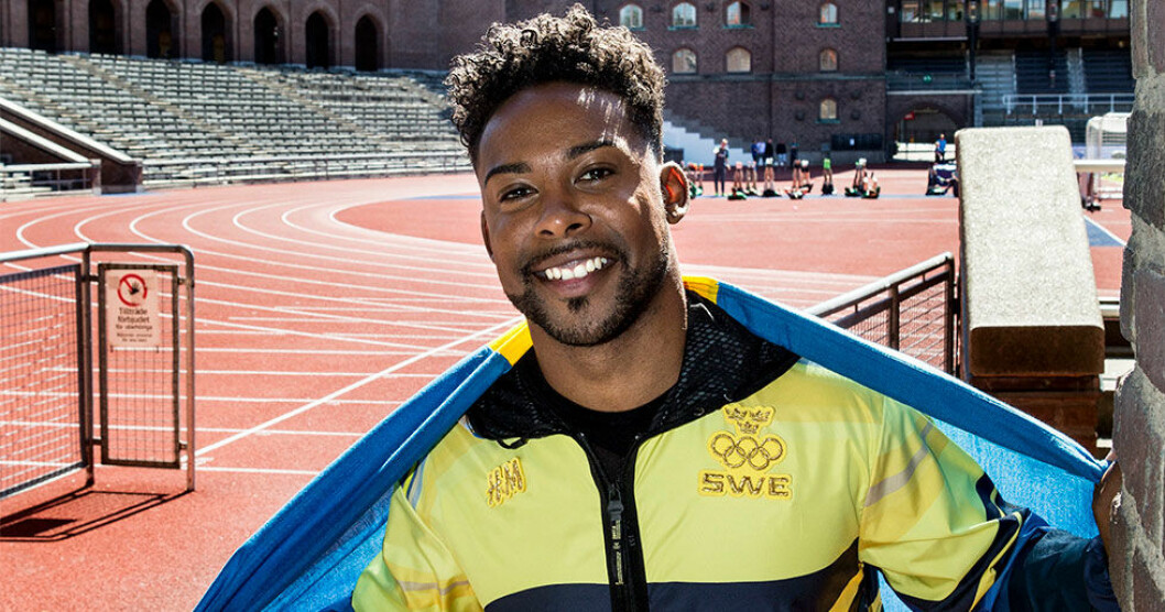 John Lundvik insvept i svenska flaggan.