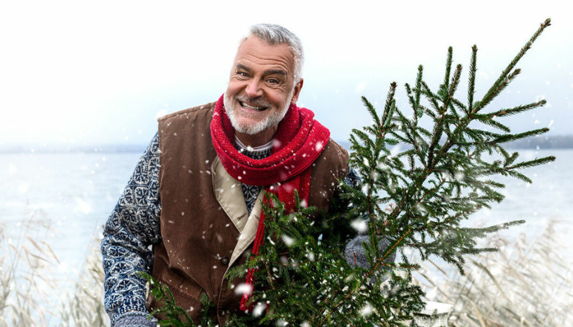 Programledaren Ernst Kirchsteiger håller en julgran i ett vinterlandskap inför nya säsongen av Jul med Ernst på Tv4.