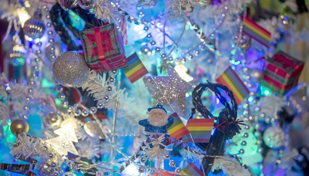 Detaljbild på en liten blå tomte och regnbågsflaggor.