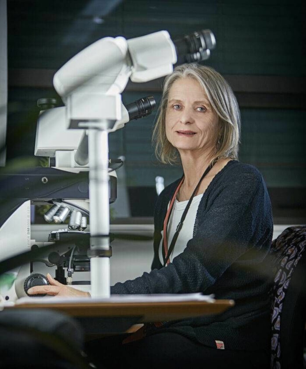 Rättsläkaren Jytte Banner vid ett mikroskop.