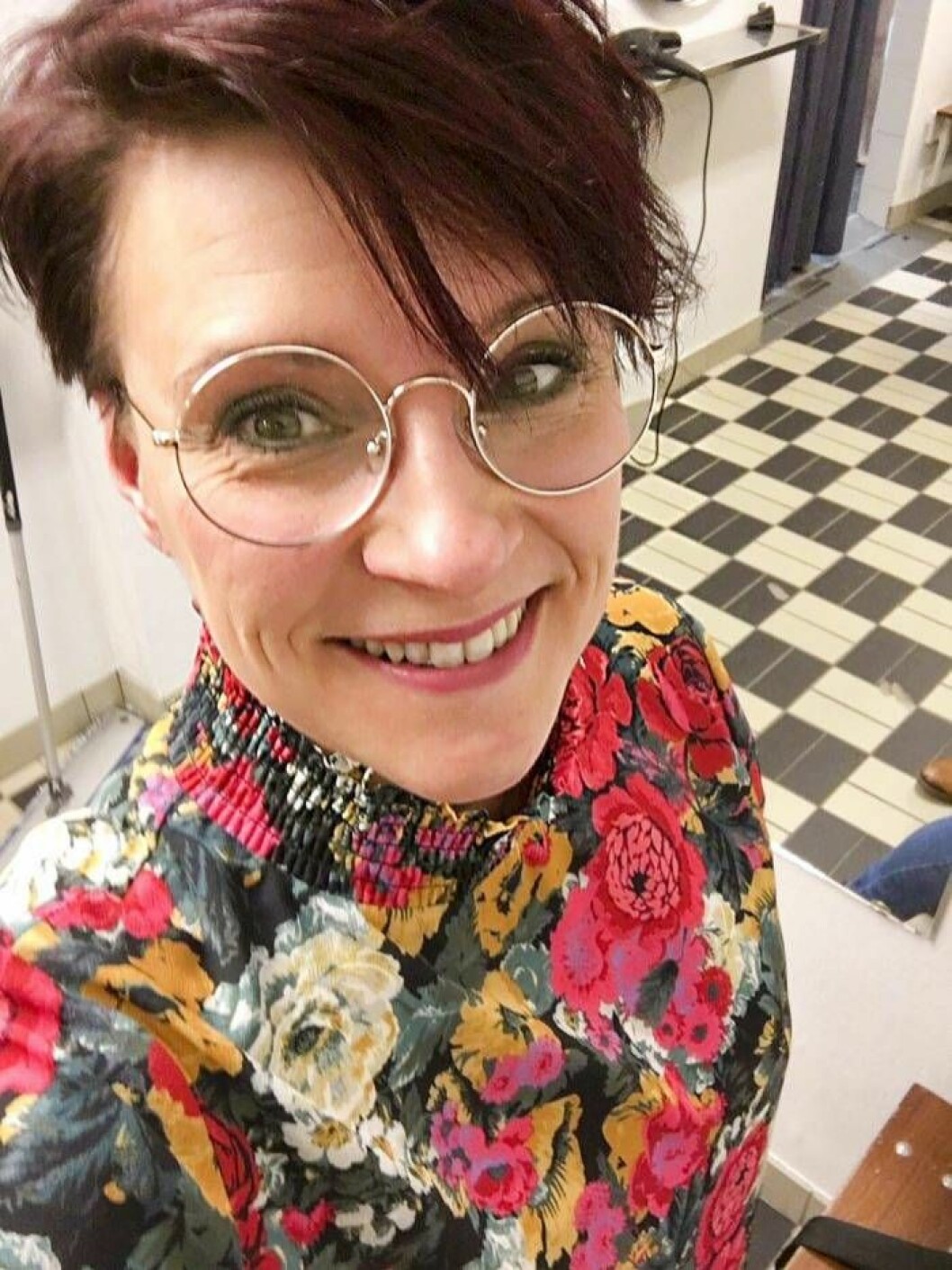 Maria Hoffstedt har fått ett positivt förhållande till mat efter KBT-kursen. Selfie av glad och pigg kvinna med stormönstrad topp, runda glasögon och kort mörkt hår.
