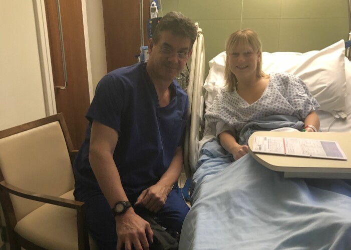Karin Eriksson i sjukhussängen tillsammans med specialisten och kirurgen Peter Barton-Smith i London.