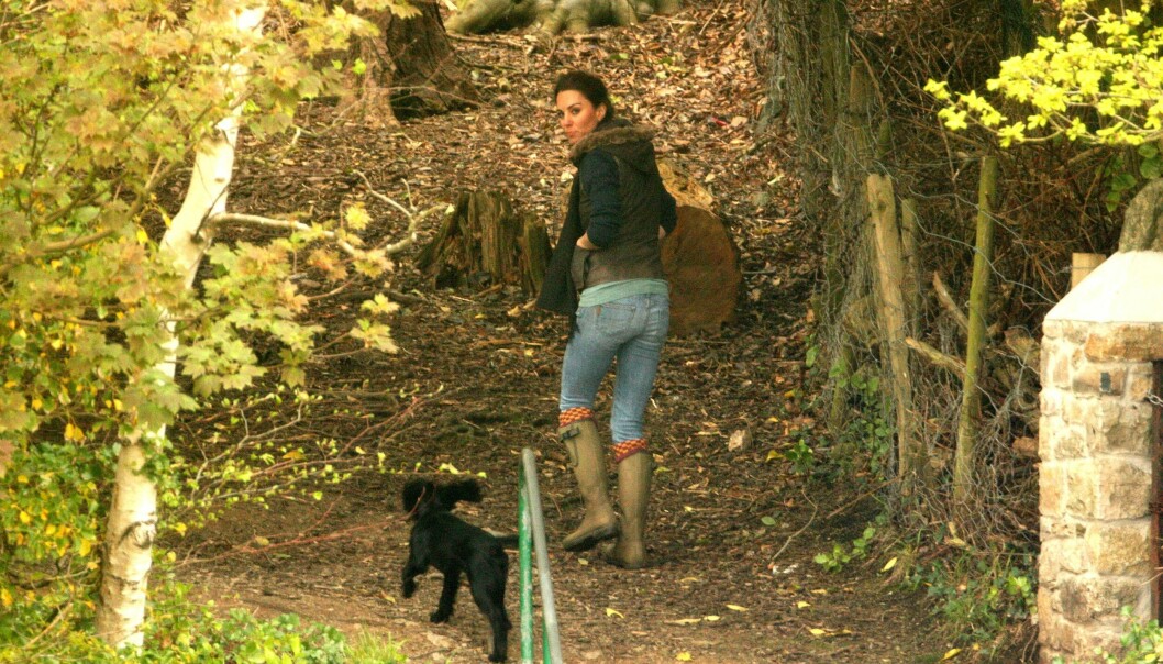 Hertiginnan Kate med cockerspanieln Lupo på promenad i skogen.