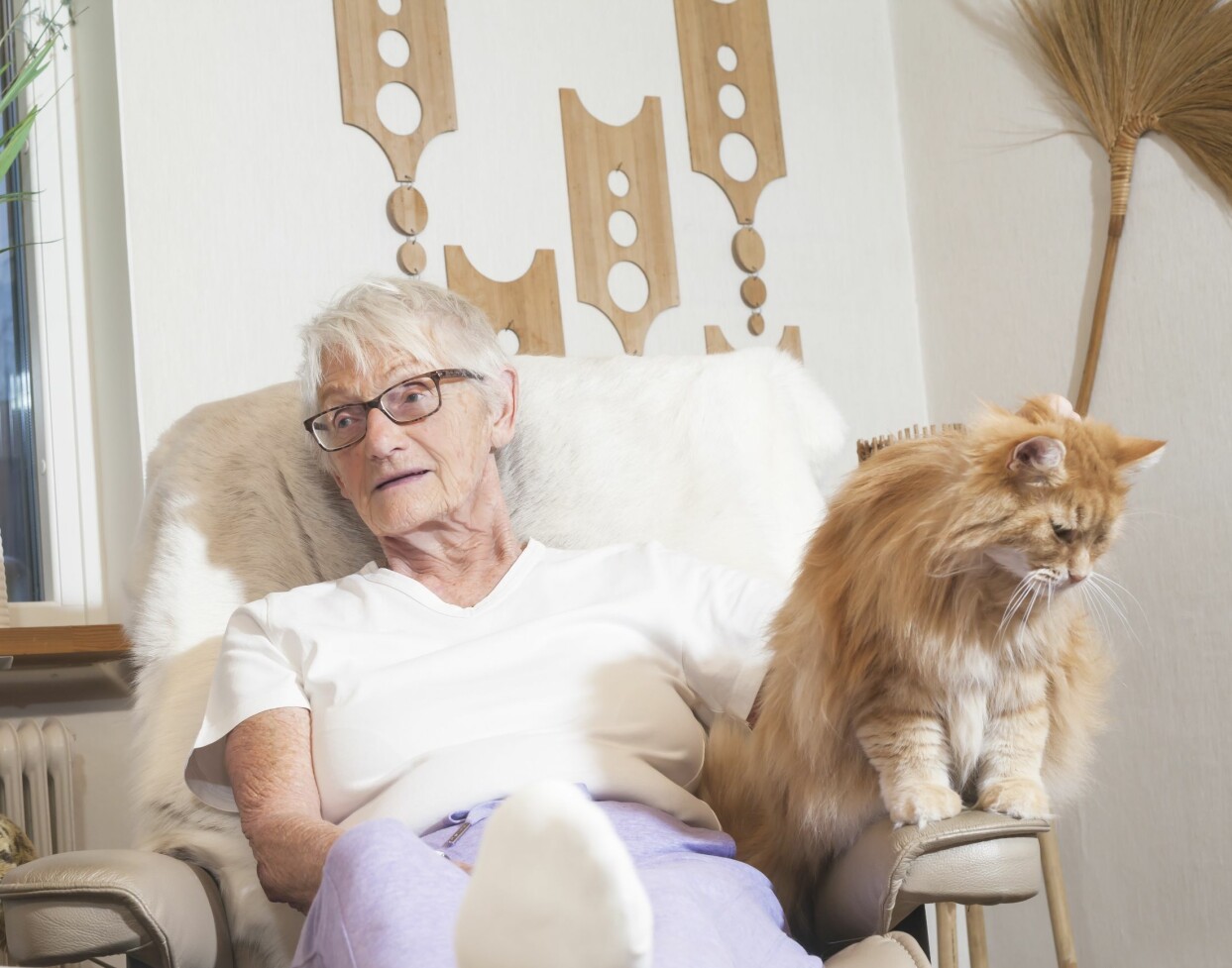 Kickan mådde så dåligt att hon försökte begå självmord flera gånger. Här tillsammans med med katten Lussan. Foto: Susanne Lindholm. Kickan kopplar av i fåtölj med röd långhårig katt på armstödet.