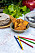 Knäckebröd, färgpennor och tallrikar på ett bord med målade kräftor