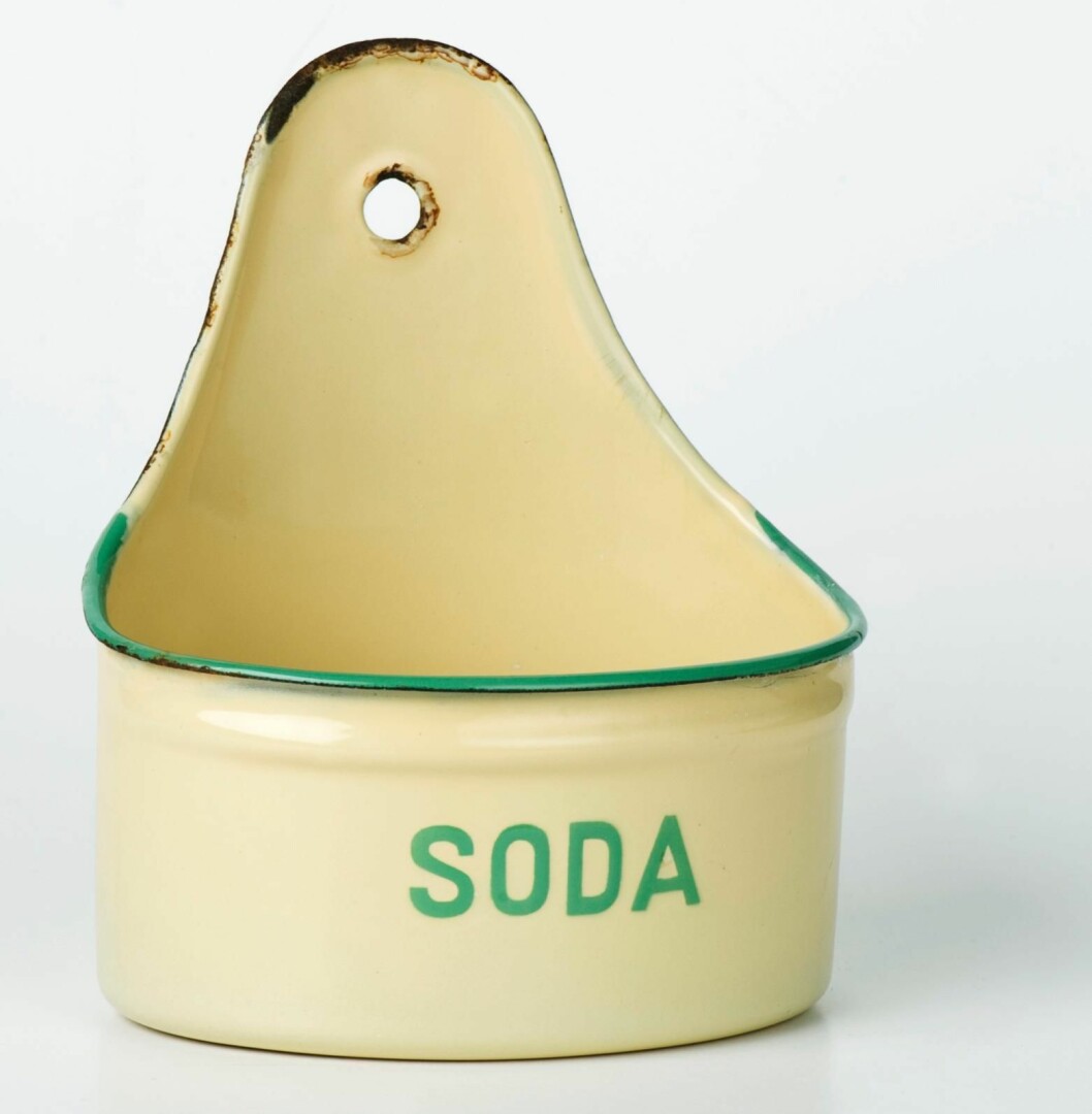 Sodabehållaren har en lite skavd kant vilket sänker värdet. Tvålkopp i ljust gul emalj med grön kant från Kockums.
