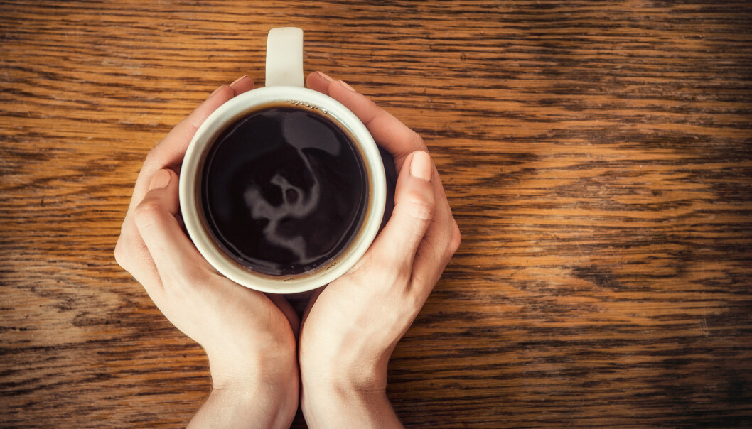 Huvudvärk på morgonen kan bero på koffeinabstinens, kanske behöver du dra ner på kaffedrickandet för att slippa morgonhuvudvärken. Foto: TT/Shutterstock Koffeinabstinens kan utlösa morgonhuvudvärk. Här håller en kvinna händerna runt en kaffekopp.
