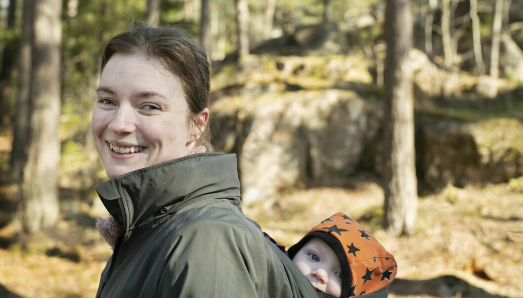 Kristin tillsammans med yngsta sonen Oliver på ryggen. Kristin Nordström tillsammans med sonen Oliver i en sele på ryggen.