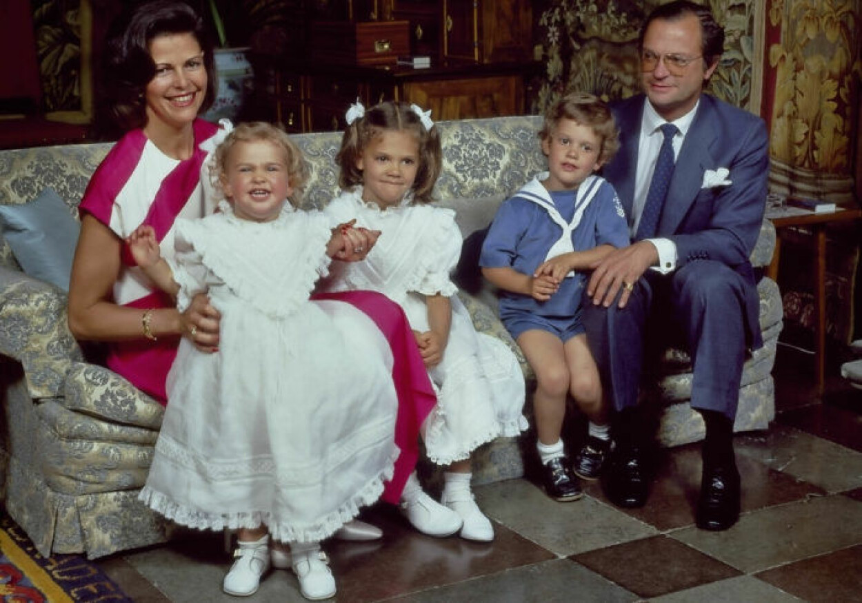 Silvia 1984.<br>I mitten av det färgstarka 80-talet var cerise och diagonala mönster hetare än hetast. Vid familjefotograferingen på Drottningholms slott sommaren 1984 lyckades drottning Silvia pricka in bägge trenderna, iförd en klänning som sytts upp speciellt för henne.