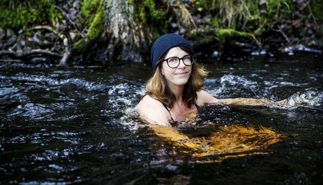 Kvinna badar kallbad i en bäck