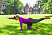 Kvinna gör en träningsövning på gräsmatta framför Sofiero slott.