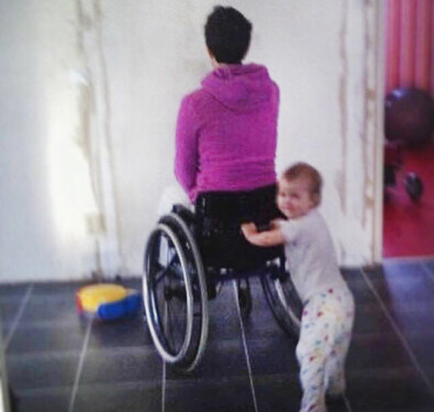 Sara tog hjälp av sina barn att lära sig gå igen. Kvinna i rullstol med sitt barn.