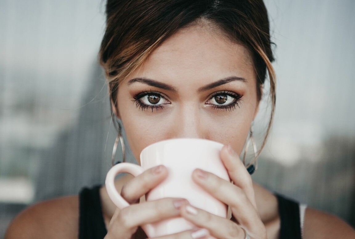 Kvinna kopplar av och dricker kaffe.
