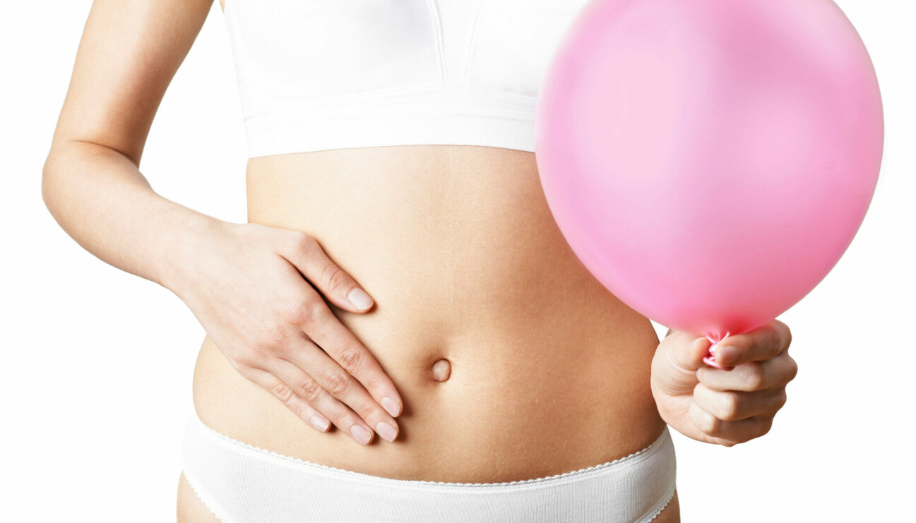 Kvinna med ballong har besvär med magen.