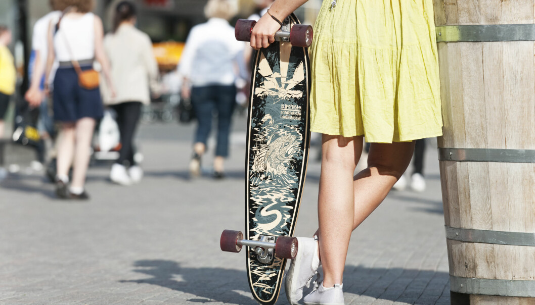 Kvinna med klänning och skateboard