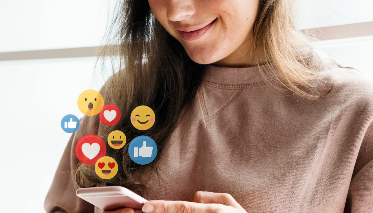 Kvinna håller i mobil som de kommer emojis ur.