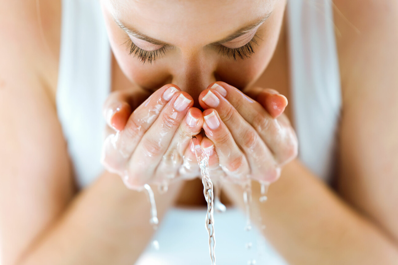 Kvinna tvättar ansiktet.