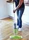 Kvinna våttorkar golv med en spraymopp.