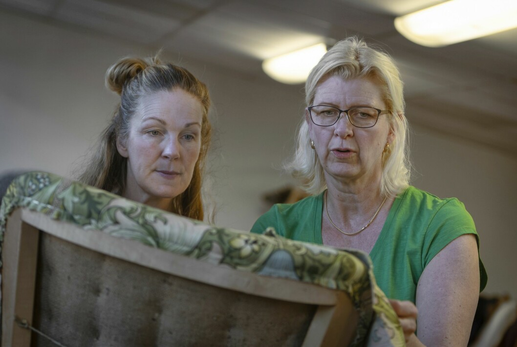 Lärlingen Anna Zander är under Petras överinseende i färd med att lägga vecken rätt och fixa snygga hörn på en Emma-fåtölj, som kläs i William Morris-tyg från England. Lärlingen Anna Zander och Petra Dolk arbetar med att få till tygvecken i stolsryggens hörn.