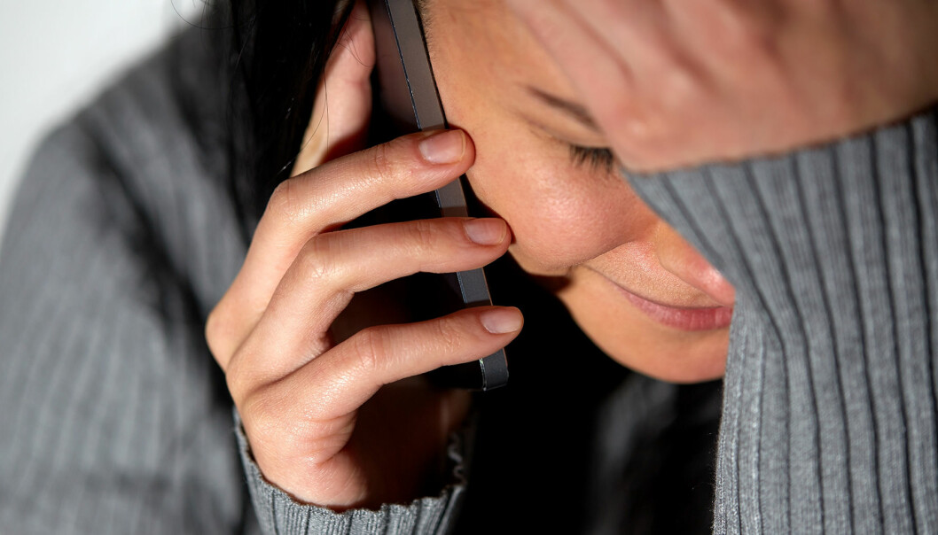 Kvinna med en telefon i handen gråter