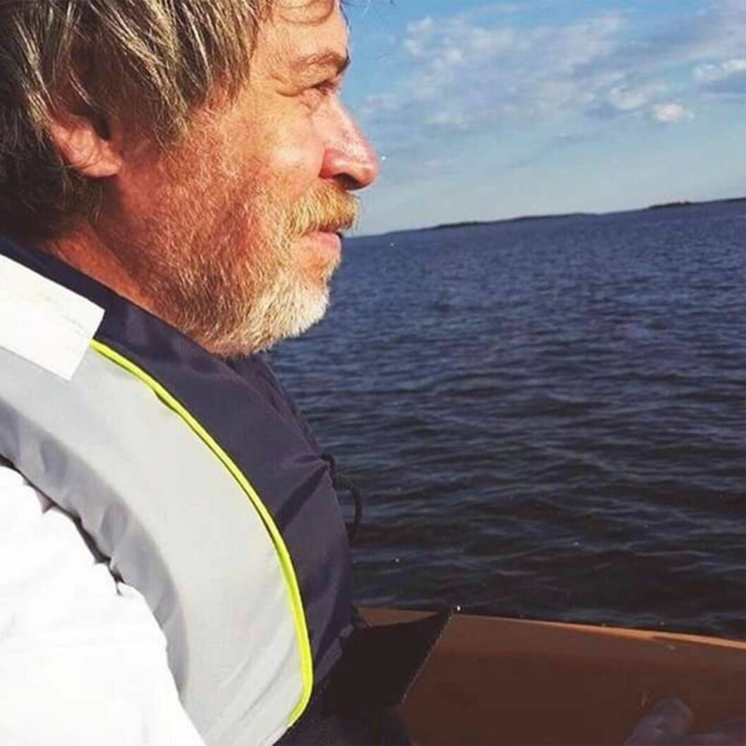 Sedan Kent gick bort i cancer har Lisa fortsatt vara familjehemsförälder på egen hand. Foto: Privat En man i flytväst, Lisas pappa Kent, sitter i en båt och blickar ut över vattnet.