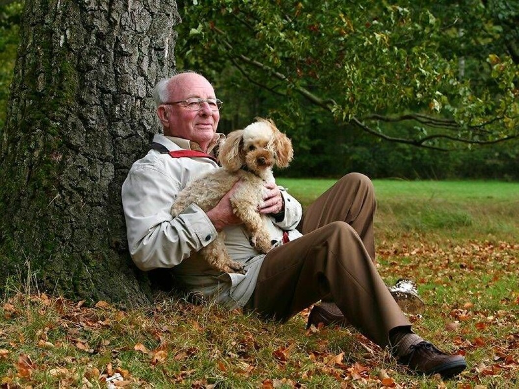Man med hund i famnen