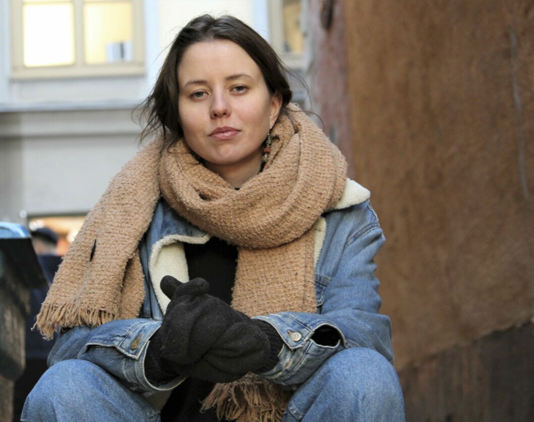 Konstnären Louise Eklund, som lidit av selektiv mutism, sitter påpälsad utomhus.