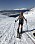 En ung kvinna på skidor i en snötäckt backe, klädd i bara shorts och top.